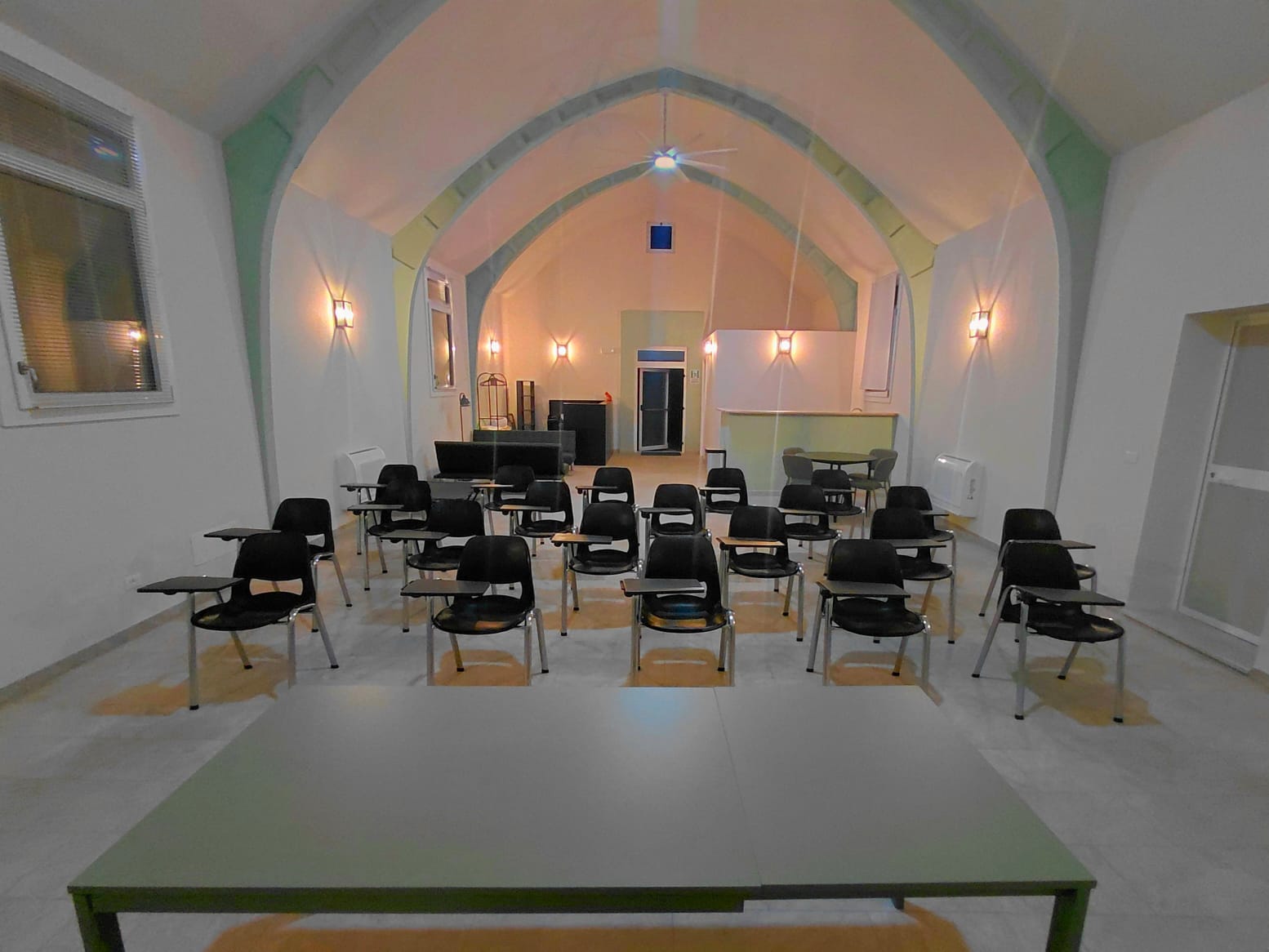 Sala corsi di Amor Cani con sedie con ribaltina e soffitto a volta